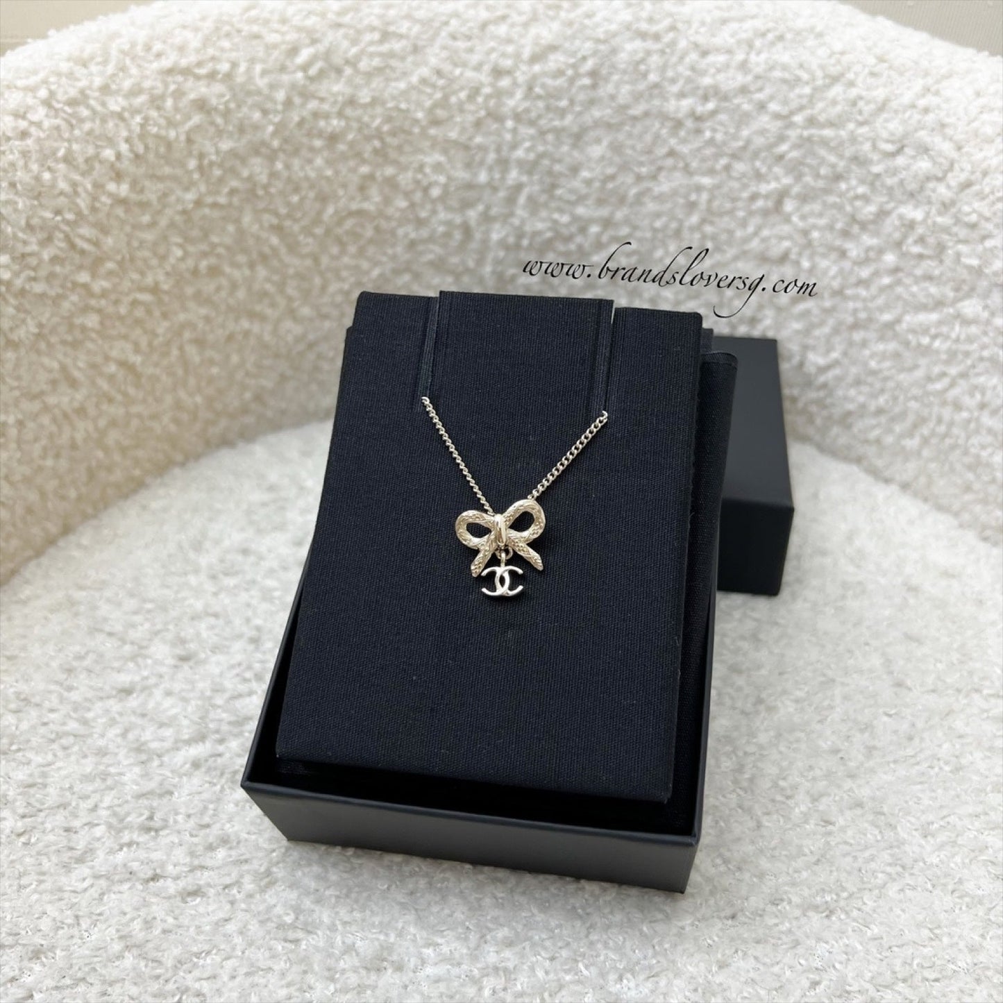 Chanel 25K Bow and Dangling Logo Necklace in SHW (Model: ABG556)